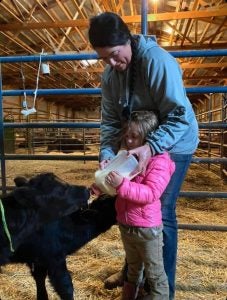 women-in-agriculture-Kacy-Atkinson-bottle-feeding-calf